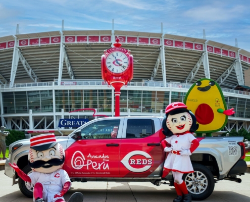 Avocados From Peru and Cincinnati Reds branded pickup truck with team mascots and an avocado mascot outside Great American Ball Park.