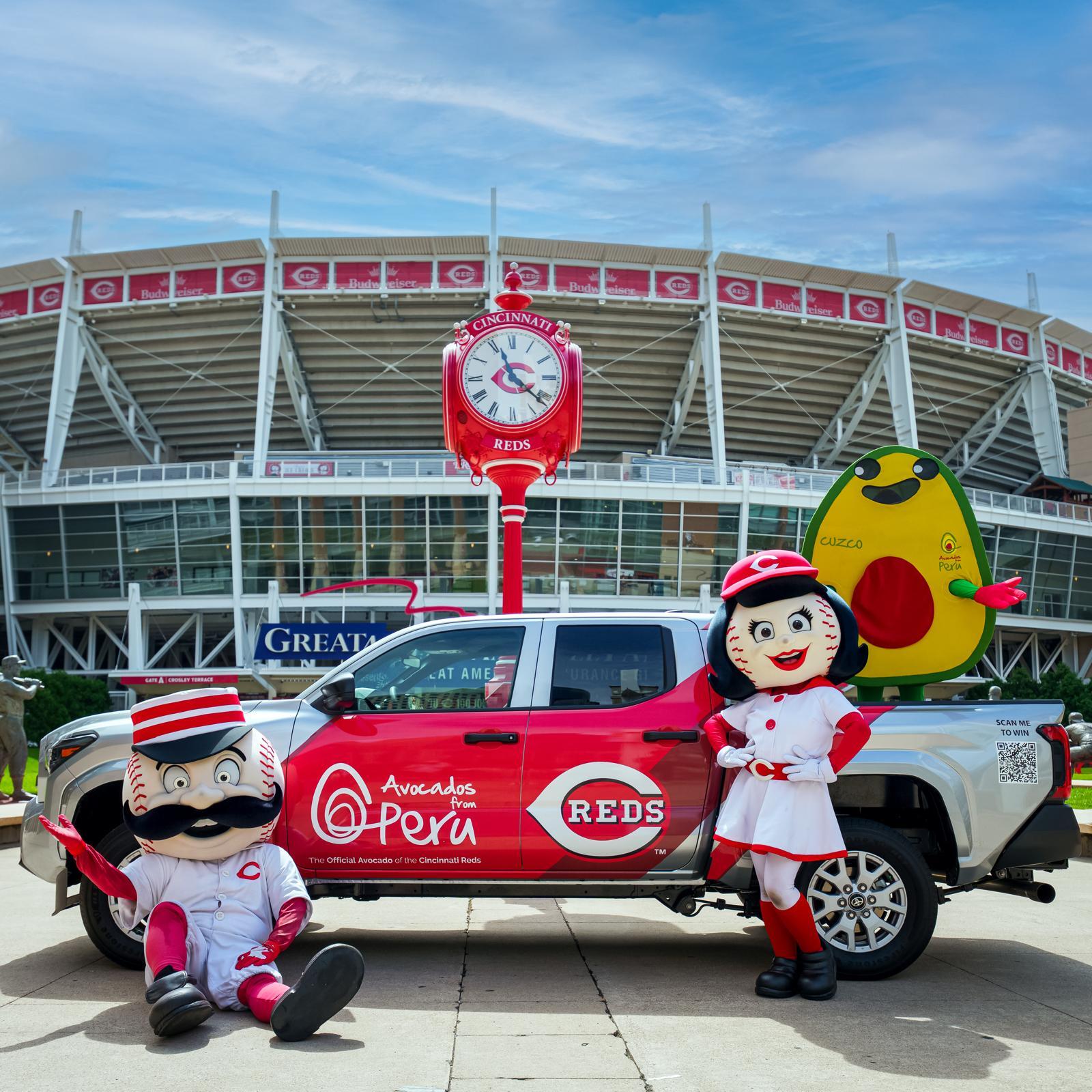 Avocados From Peru and Cincinnati Reds branded pickup truck with team mascots and an avocado mascot outside Great American Ball Park.